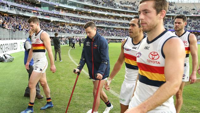 Luke Brown hobbles off with an injured ankle after the Crows’ loss in Perth. Picture: Paul Kane/Getty Images