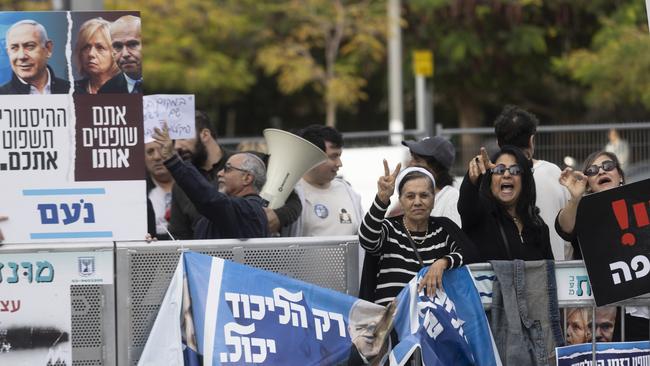 Protesters hold signs and photos during a demonstration supporting Israeli Prime Minister Benjamin Netanyahu outside Tel Aviv's court. Picture: Getty Images.