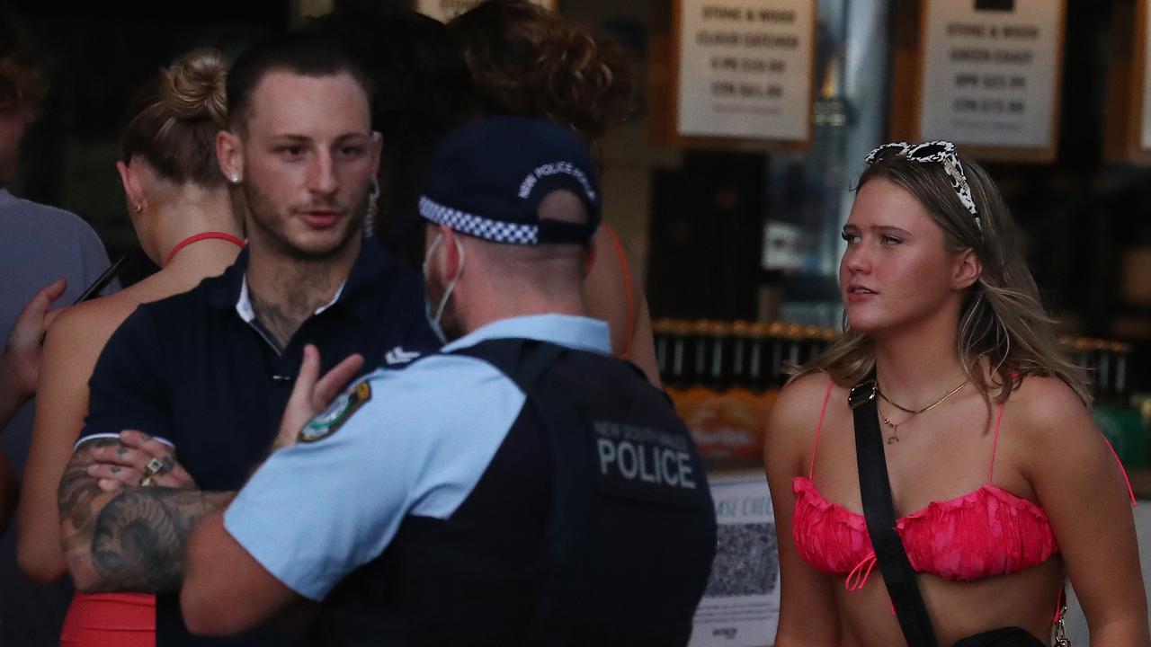 A security guard talks with a police officer at the Beach Hotel in Byron Bay. Picture: Jason O'Brien