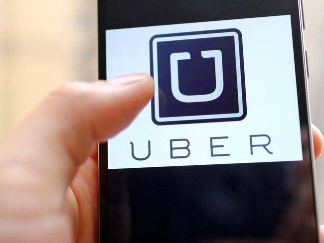 --FILE--A mobile phone user shows the logo of car-hailing app Uber on his smartphone in Chengdu city, southwest China's Sichuan province, 6 May 2015. U.S. firm Uber Technologies Inc and Chinese rival Didi Kuaidi are taking steps to operate legally in China, a key market for both firms but where their car hailing services currently operate in a regulatory prey zone. Uber China said in a statement on Thursday (8 October 2015) it was "actively preparing" documents to apply for a license to operate an online car-hailing platform to meet new regulations governing the sector that are expected to be announced soon. Didi Kuaidi, a $16 billion valued firm backed by Chinese Internet giants Alibaba Group Holding Ltd and Tencent Holdings Ltd, also said on Thursday it had received a car booking license for its operations in Shanghai and that it was seeking more licenses from other cities.