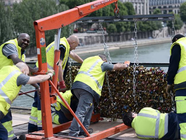 Moving on ... yellow-vested officials were out early on Monday morning on the city’s iconic Pont des Arts, cutting off the padlocks. Picture: AFP/Stephane De Sakutin