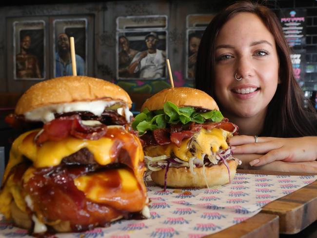 Milky Lane is known for its decadent burger options and has the tick of approval from plenty of celebrities. Bartender Hayley Yaworski with some burgers. Picture Glenn Hampson