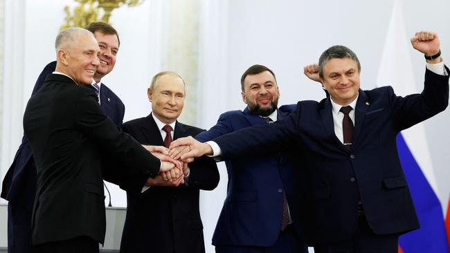 The Moscow-appointed heads of Kherson region Vladimir Saldo and Zaporizhzhia region Yevgeny Balitsky, Russian President Vladimir Putin, Donetsk separatist leader Denis Pushilin and Lugansk separatist leader Leonid Pasechnik join hands after signing treaties formally annexing four regions of Ukraine occupied by Russian troops. Picture: AFP