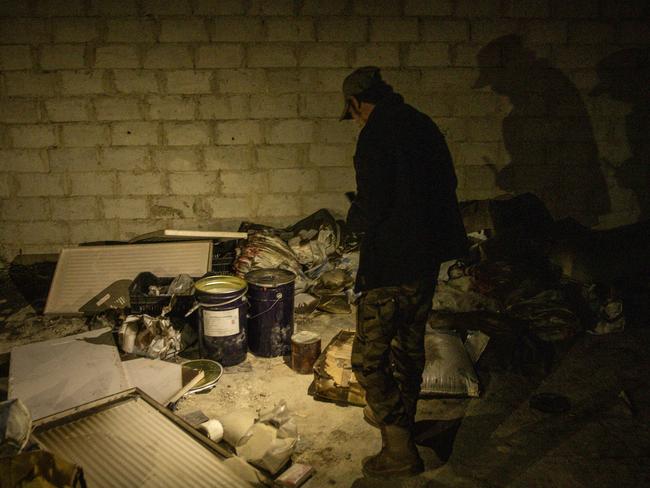 A rebel fighter looks at equipment and chemicals used to make illicit pills at a large drug factory controlled by the Assad regime. Picture: McGrath/Getty Images