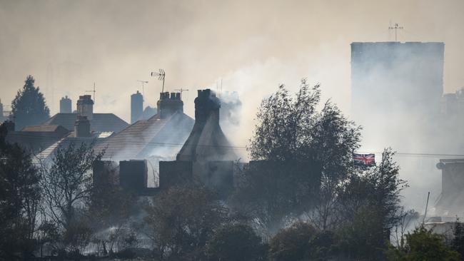 Smouldering ruins of houses at Wennington, Greater London, where a series of grass fires broke out amid an intense heatwave this week