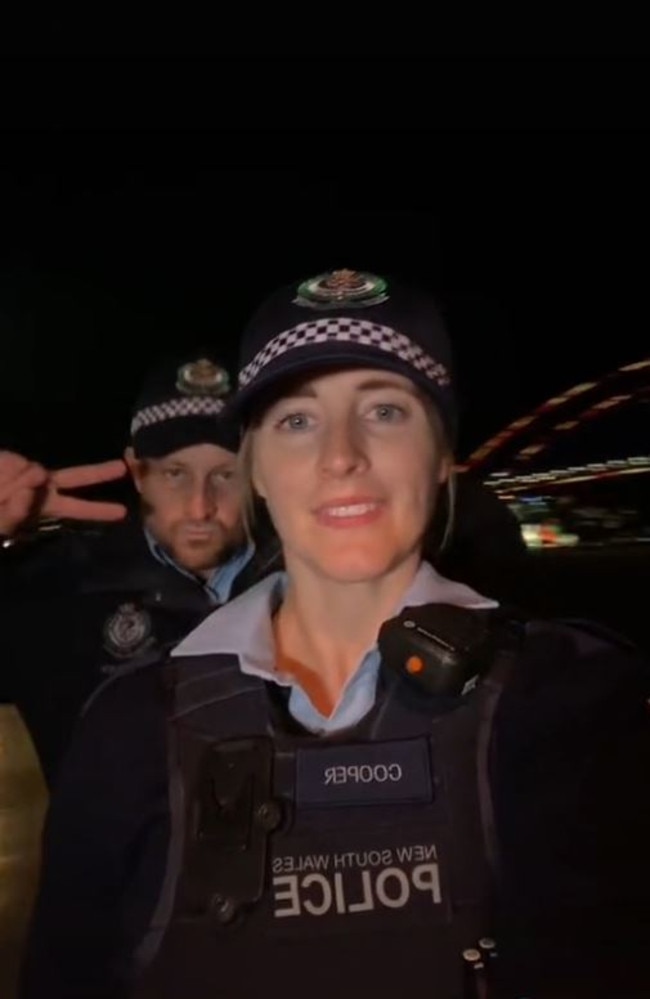 The video transitions to the same police officer with his partner smiling in front of Sydney's Vivid.