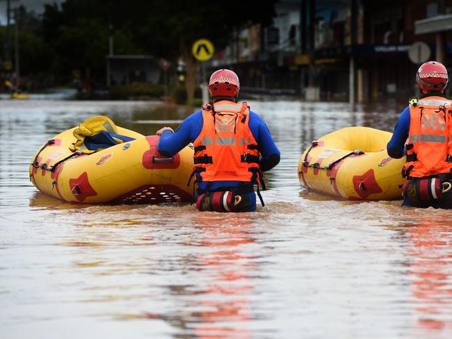 SES and police emergency crews move through the centre of Lismore looking for people in need of evacuation.