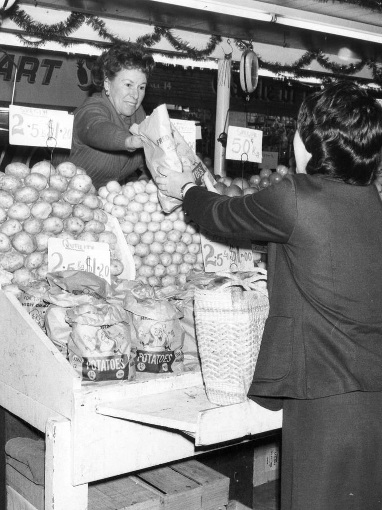 Marie Roberts buys spring potatoes, 1980.