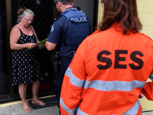 Jan Bridges (left) looks on after advising Police and SES that she will not evacuate her house, situated in a low lying of Ayr, south of Townsville yesterday. Picture: Dan Peled/AAP