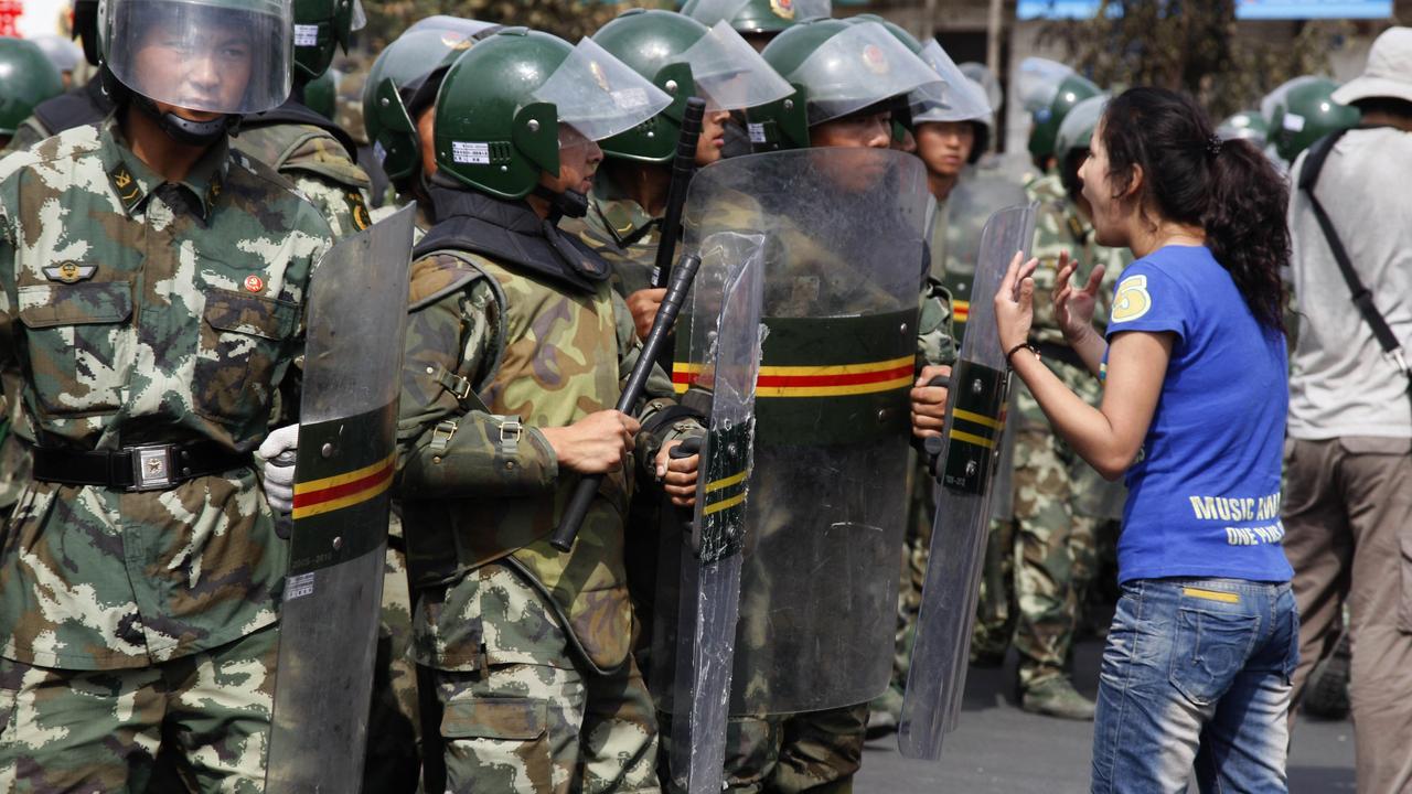 An Uighur woman protests before a group of paramilitary police in Urumqi, capital of northwest Xinjiang Uygur Autonomous Region, China 07 Jul 2009.