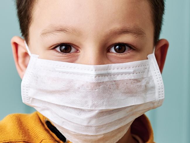 CORONAVIRUS:  6-7 years old cute child wearing surgical mask.