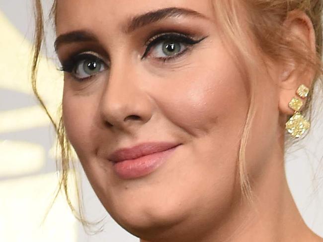 (FILES) This file photo taken on February 12, 2017 shows Adele posing in the press room with her trophies during the 59th Annual Grammy music Awards on February 12, 2017, in Los Angeles. Adele has confirmed years of speculation that she is married. The English singer has been in a long-term relationship with Simon Konecki, a former financier who founded drop4drop, a charity that presses for global access to clean drinking water. She confirmed their status at a concert in Brisbane, Australia on March 5, 2017. / AFP PHOTO / Robyn BECK
