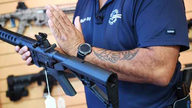 A salesman in a gun store in Virginia shows a bump stock installed on an AR-15 rifle. Pic: AFP