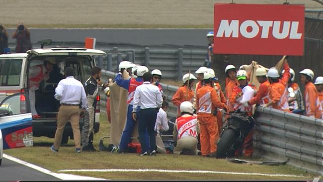 Medical staff attend to Alex de Angelis after his crash at Motegi.