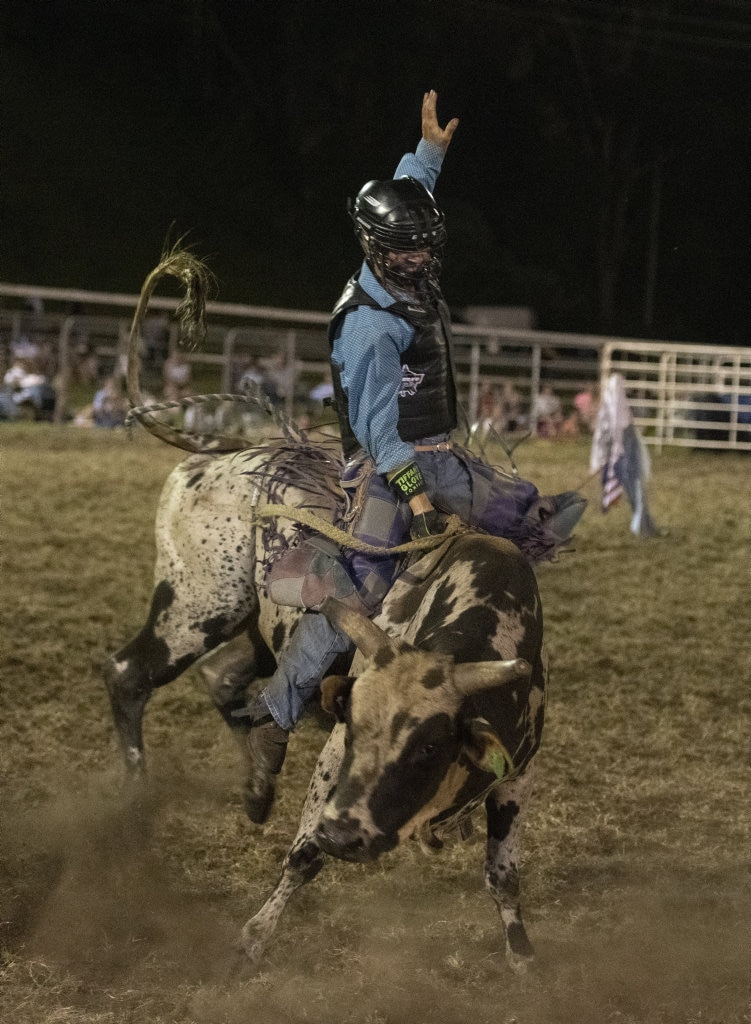 Cade Rossiter shows good style in the junior bullride at the Lawrence Twilight Rodeo. Picture: Adam Hourigan