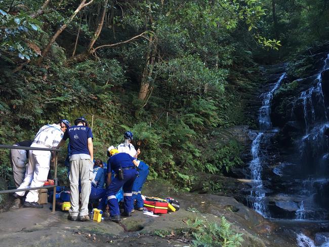 Rescuers stabilise the woman before continuing to carry her to safety. Picture: Tim Hunter