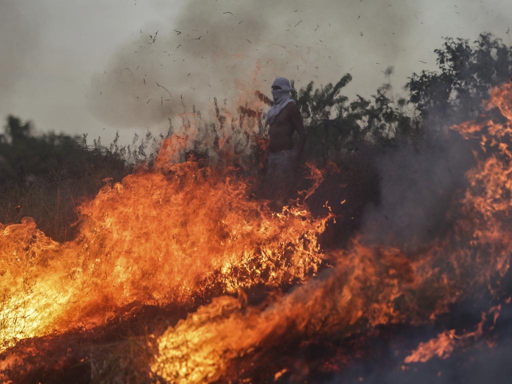 A protestor stands behind a fire during a protest at the border between Brazil and Venezuela. Picture: AP