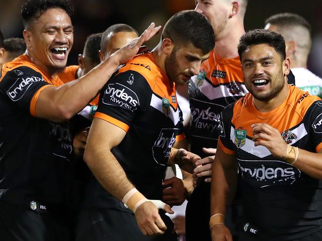 SYDNEY, AUSTRALIA - AUGUST 23:  Tigers players congratulate Moses Mbye of the Tigers after scoring a try during the round 24 NRL match between the Wests Tigers and the Manly Sea Eagles at Campbelltown Sports Stadium on August 23, 2018 in Sydney, Australia.  (Photo by Cameron Spencer/Getty Images)