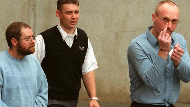 A guard, centre, escorts “bodies in the barrels serial killers John Justin Bunting, left, and Robert Joe Wagner, right, into court following their arrest.