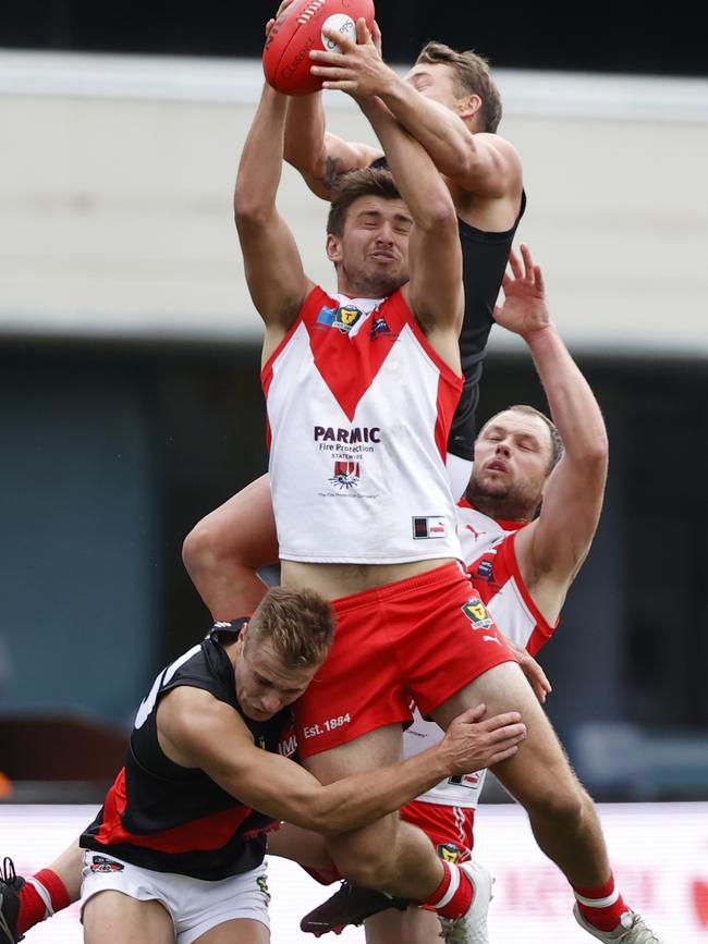 Clarence’s Jarrod Harper marks under strong pressure from his North Launceston opponents. Picture: Zak Simmonds