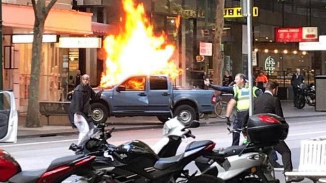 A car on fire on Bourke St during the deadly incident. Picture: Chris Macheras