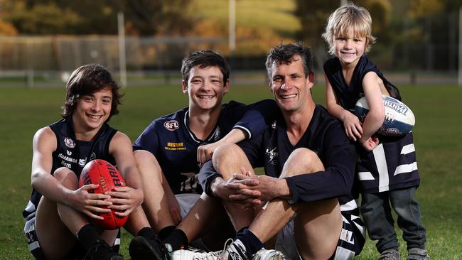 Noarlunga Football Club 400-game veteran Jason Peach with his children Hayden, Jesse and Harry. Picture: Calum Robertson