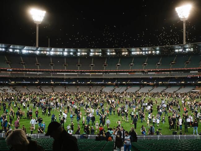 Fans enjoy a kick of the footy on the MCG.