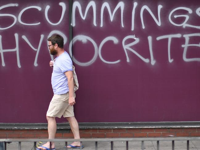 A shopper in front of graffiti deriding number 10 special advisor Dominic Cummings outside a supermarket near his residence in north London. Picture: AFP