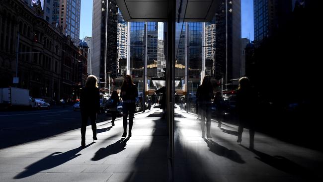 Pedestrians are seen reflected at the Australian Securities Exchange (ASX) in Sydney. (AAP Image/Mick Tsikas)