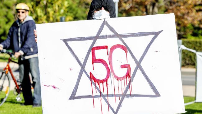 A man holds a sign in protest against 5G. Picture: Tim Carrafa