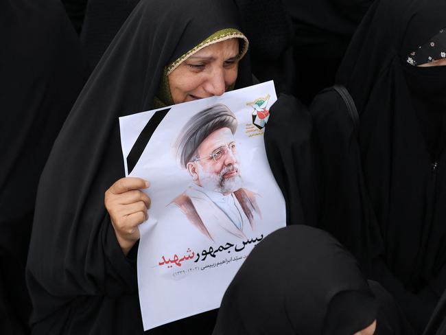 This handout picture provided by the Iranian president's office shows a mourner holding a portrait of late president Ebrahim Raisi during a funeral procession in Tabriz. Picture: AFP