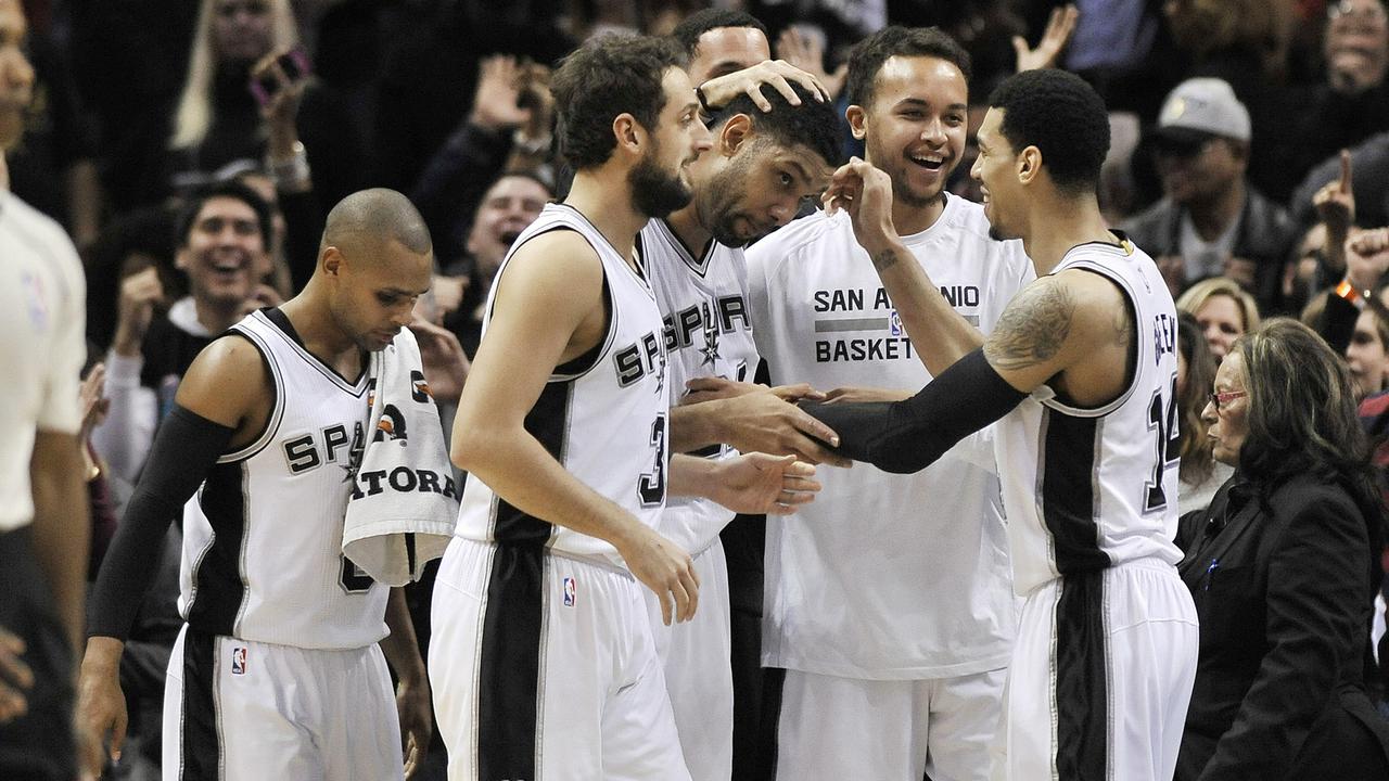 Fans cheer as San Antonio Spurs forward Tim Duncan is congratulated by teammates after scoring a basket, with less than one second left in the second half, to send an NBA basketball game against the New Orleans Pelicans into overtime, Wednesday, Dec. 31, 2014, in San Antonio. San Antonio won 95-93 in overtime. (AP Photo/Darren Abate)