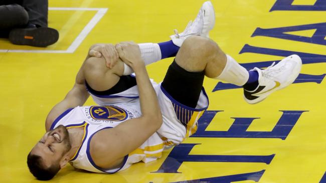 Andrew Bogut #12 of the Golden State Warriors holds his knee in pain after sustaining an injury during the third quarter against the Cleveland Cavaliers in Game 5 of the 2016 NBA.