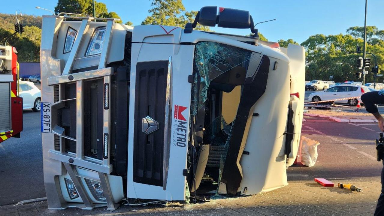 Truck driver’s lucky escape after rollover at base of busy freeway