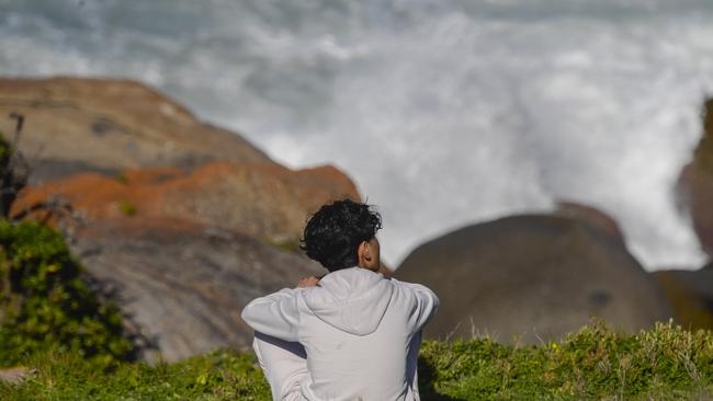 The brother of the missing teen, Sahil Habibi looks out over the rocks. Picture: NewsWire / Roy VanDerVegt