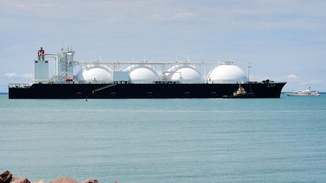 A natural gas container ship dwarfs a yacht in Darwin Harbour as it departs from the Ichthys LNG Project. Picture: Justin Kennedy
