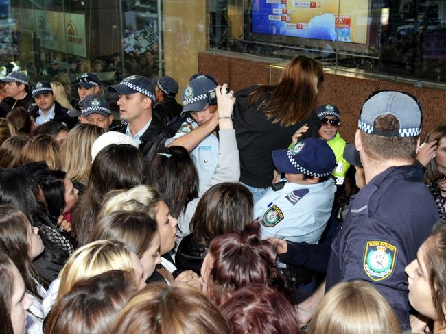 Police help Justin Bieber fans out of the crush as they look on as singer Justin Bieber performs on the set of ‘Sunrise’ at the Channel 7 studios in Martin Place, Sydney.