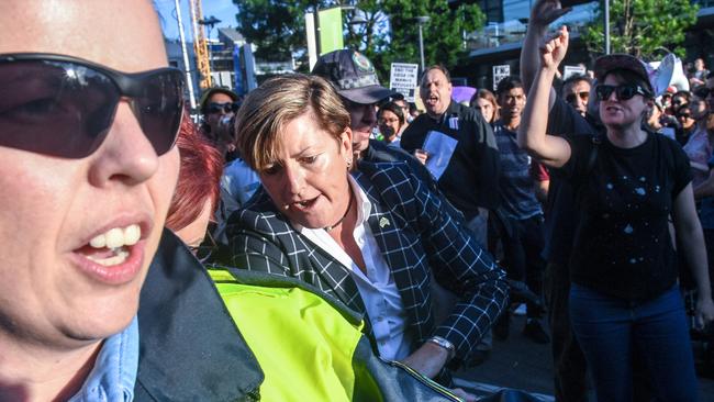 Christine Forster struggles through protesters outside a fundraiser for her brother Tony Abbott in Sydney last night. Picture: AAP