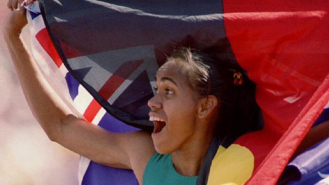 Cathy Freeman flies the Australian and Aboriginal flags in 1994.