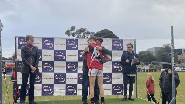 Aidan O'Rafferty receives the best on ground medal from club legend Barry Priest. Photo: Brayden May.