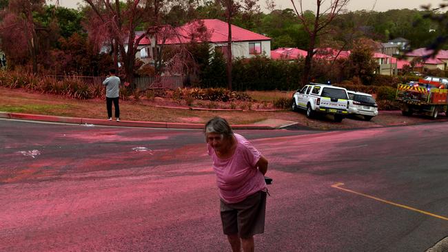 A resident walks infront of South Turramurra homes which were bombed by fire-retardant during NSW RFS firefighting efforts on November 12, 2019 in Sydney, Australia. Picture: Sam Mooy/Getty Images.