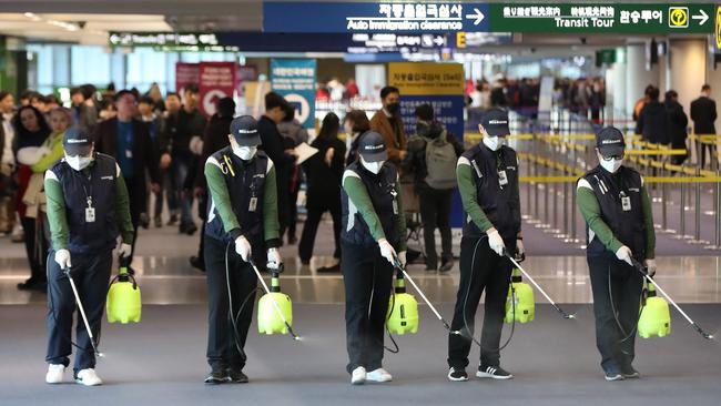 Cleaners spray disinfectant in the Customs and immigration area of Incheon international airport, west of Seoul, on Wednesday. Picture: AFP