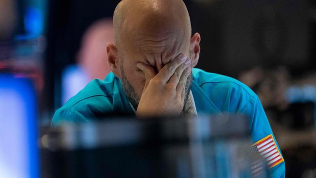 A trader wipes his eyes as he watches stock prices at the New York Stock Exchange August 23, 2019 in New York. - Wall Street stocks tanked Friday after President Donald Trump vowed a tough response to new Chinese tariffs, escalating the trade war between the world's top two economies amid rising fears of recession. The Dow Jones Industrial Average sank more than 600 points, or 2.4 percent, to 25,628.90, registering its fourth straight weekly loss. (Photo by Don Emmert / AFP)