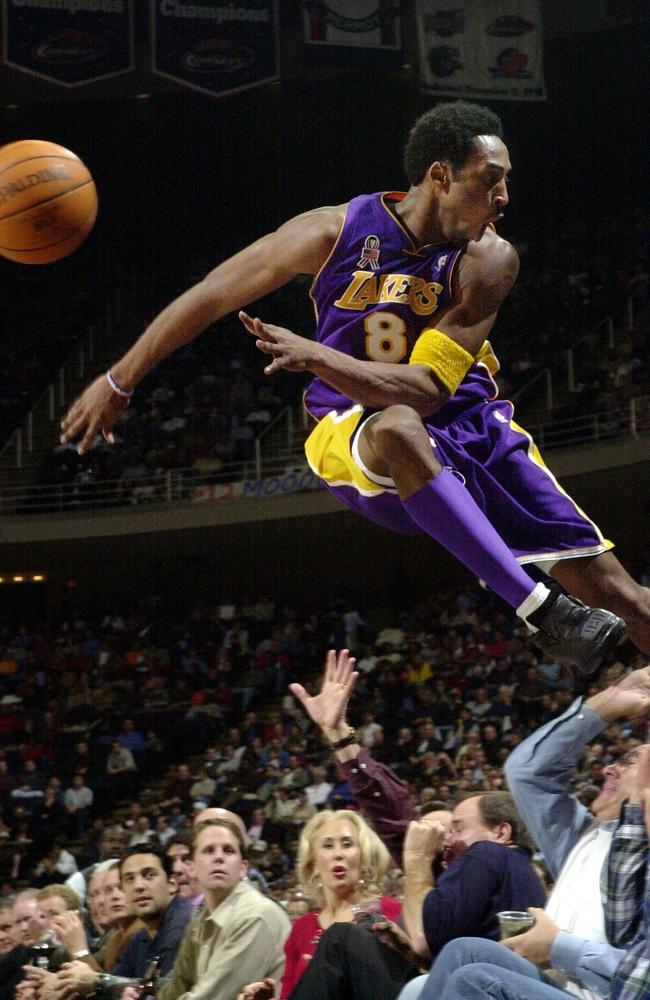 Los Angeles Lakers' Kobe Bryant jumps over a row of fans after saving the ball from going out of bounds in the second half of the Lakers 107-101 win over the Houston Rockets in Houston in 2001. Picture: AP