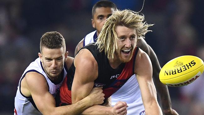 MELBOURNE, AUSTRALIA - MAY 18: Dyson Heppell of the Bombers handballs whilst being tackled during the round nine AFL match between the Essendon Bombers and the Fremantle Dockers at Marvel Stadium on May 18, 2019 in Melbourne, Australia. (Photo by Quinn Rooney/Getty Images)