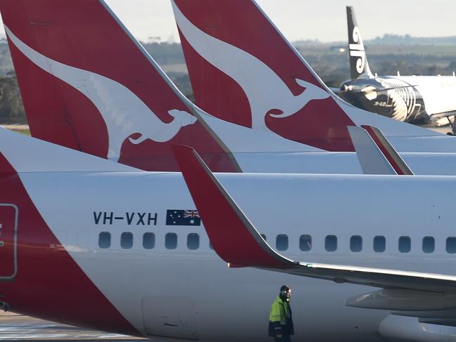 A worker checks the wings for ice.  Qantas planes, Melbourne airport.  Melbourne has shivered through a cold Winter's morning.  Picture: Nicole Garmston