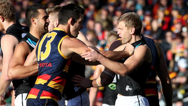 Taylor Walker and Kane Cornes get up close and personal in 2014. Picture: Simon Cross.