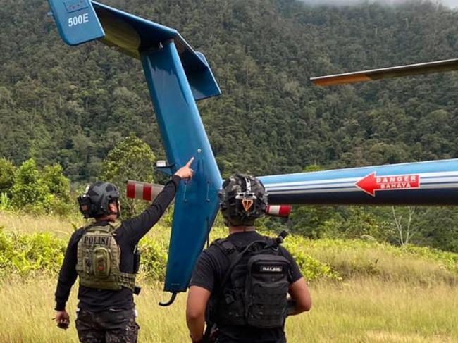 This handout photograph taken and released by the Cartenz Peace Taskforce on August 6, 2024, shows members of a joint task force of police leading an investigation at the site where a New Zealand helicopter pilot was shot dead by rebels the day before, in Mimika Regency, Central Papua. Glen Malcolm Conning, 50, a pilot for PT Intan Angkasa Air Service, was killed on August 5, 2024, after landing in Papua with four Indonesian health workers and two children, all of whom survived. (Photo by Handout / CARTENZ PEACE TASK FORCE / AFP) / RESTRICTED TO EDITORIAL USE - MANDATORY CREDIT "AFP PHOTO / Cartenz Peace Taskforce" - NO MARKETING NO ADVERTISING CAMPAIGNS - DISTRIBUTED AS A SERVICE TO CLIENTS