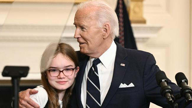 Joe Biden embraces Miriam Butorin, the 12-year-old daughter of Aslu Kurmasheva, as he speaks about the prisoner exchange with Russia. Picture: AFP.