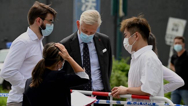 Canadian ambassador Dominic Barton talks to his staff outside the Dandong detention centre after attending the sentencing of Michael Spavor. Picture: AFP